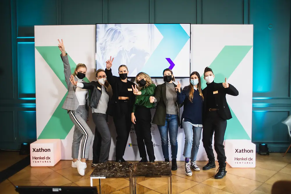 Participants cheer on in front of a banner of the Xathon.