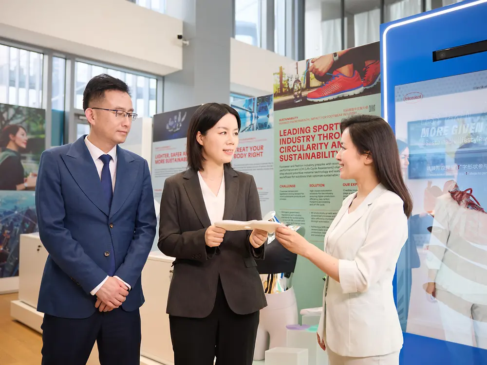 A customer experience tour guide presents a shoe sole to a group of customers in the Permanent Exhibition of the Henkel Adhesive Technologies - Inspiration Center Shanghai.